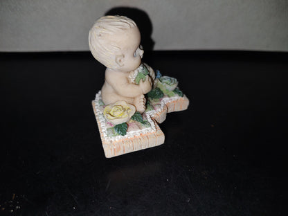 A3- Figura De Resina. Bebé Sentado Sosteniendo Cojín En Forma De Corazón - 90'S