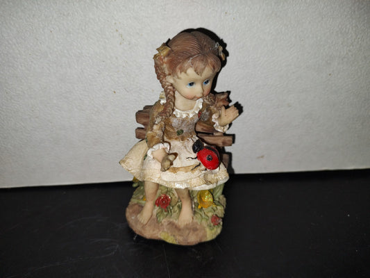 A6- Figura De Resina: Niña De Trenzas Sentada En Banca De Madera Con Mariquita En Las Piernas - 80'S